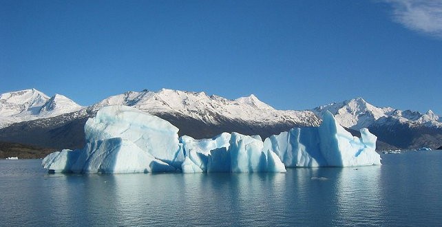 Blue glacial iceberg floating along the coast Blue glacial iceberg floating along the coast